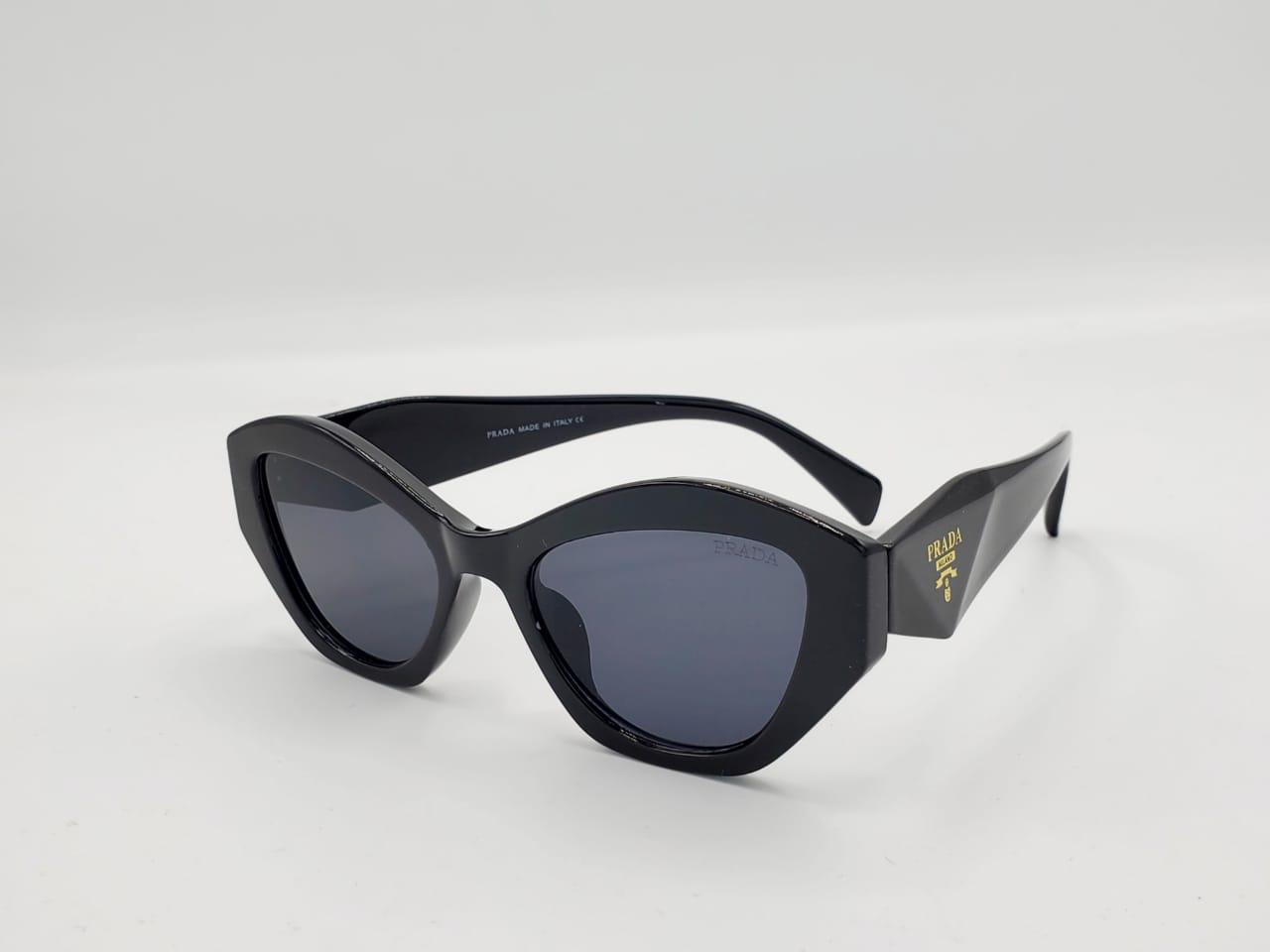 Black cat-eye sunglasses with thick frame and dark lenses on a white background